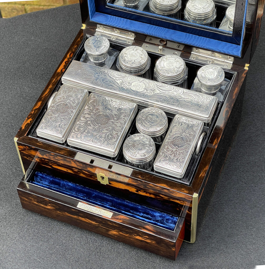 Overhead internal view of the silver mounted bottles from a  Miniature Antique Dressing Case in Coromandel, by Betjemann and Sons.