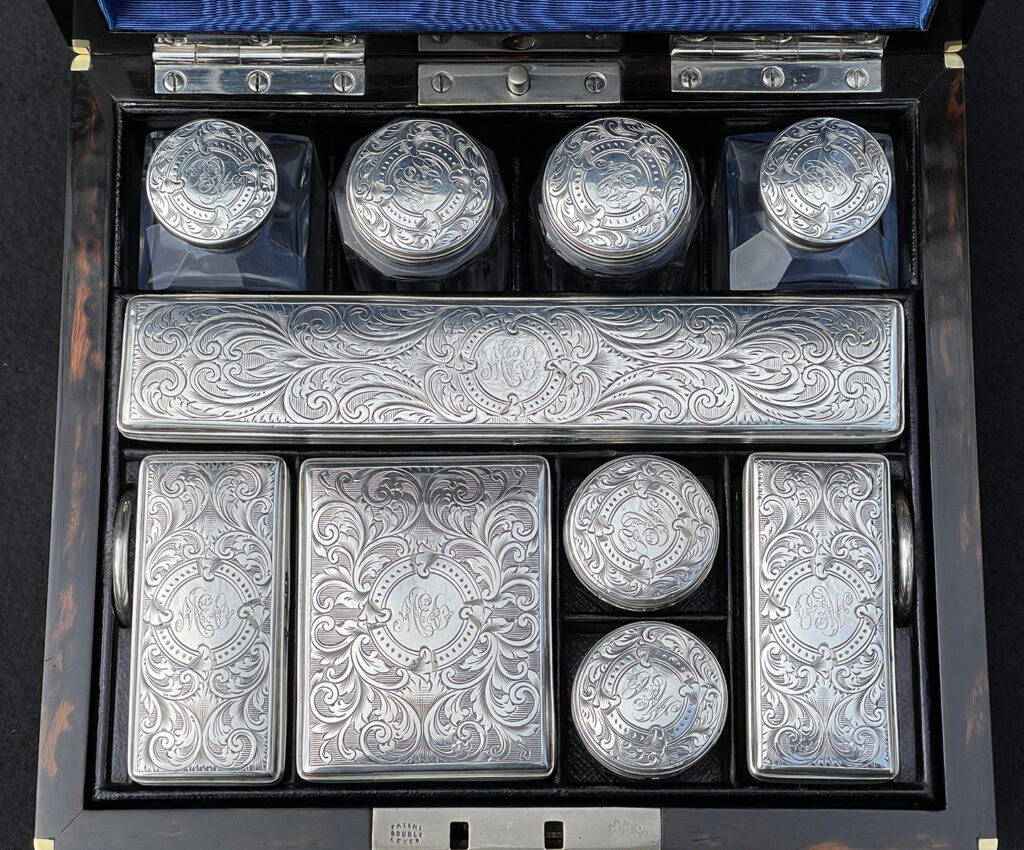Close up view of the silver mounted bottles from a Miniature Antique Dressing Case in Coromandel, by Betjemann and Sons.