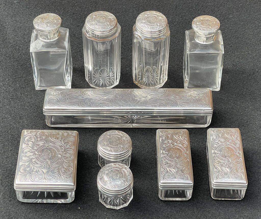 View of the silver mounted bottles and jars from a Miniature Antique Dressing Case in Coromandel, by Betjemann and Sons.