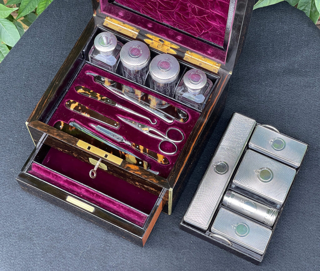 Close up internal view of the silver mounted bottles and vanity tool tray from a Miniature Antique Gentleman’s Dressing Case in Calamander.