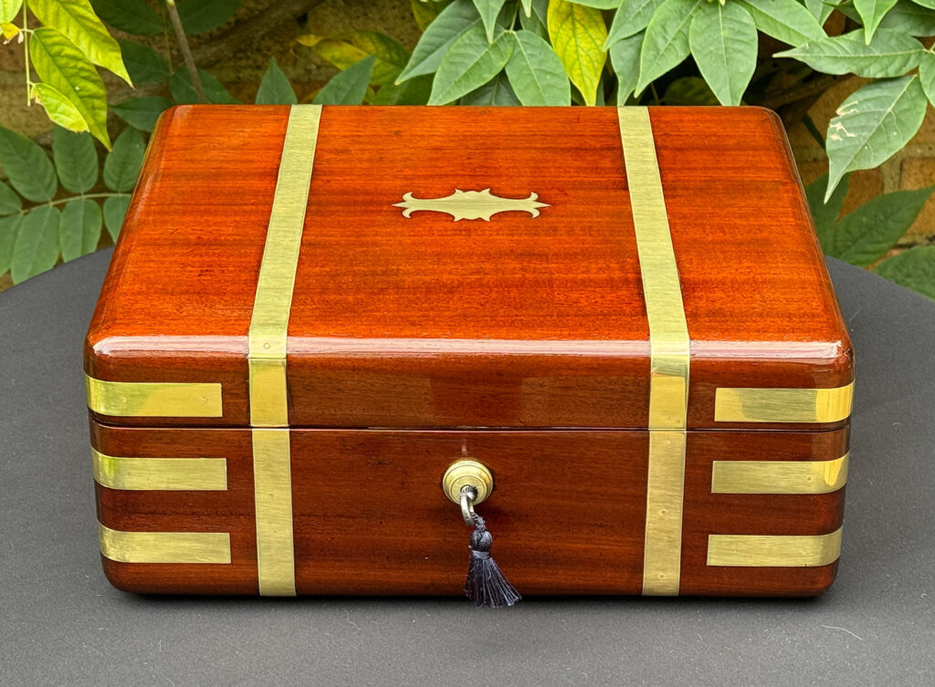 Front view of an Antique Radial Edged Travelling Jewellery Box in Mahogany.