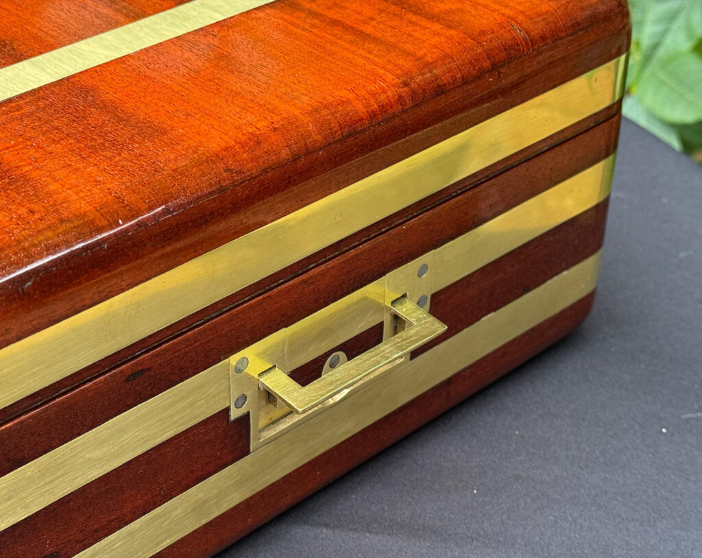 Close up of side handle from an Antique Radial Edged Travelling Jewellery Box in Mahogany.