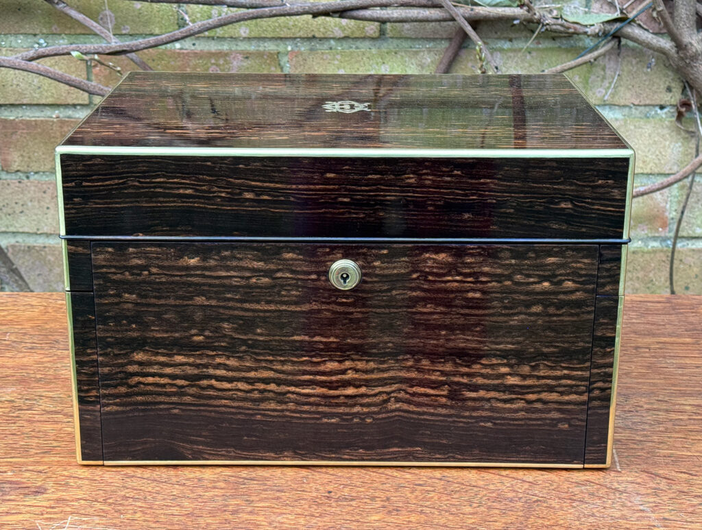 Front view of an Antique Jewellery Box in Coromandel with Betjemann Patent Automatic Mechanism, by Fisher.