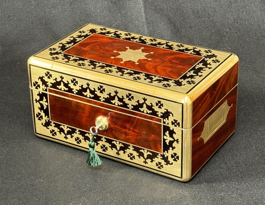 Front right view of an Antique Miniature Jewellery Box in Flame Mahogany with Brass & Ebony Inlay.