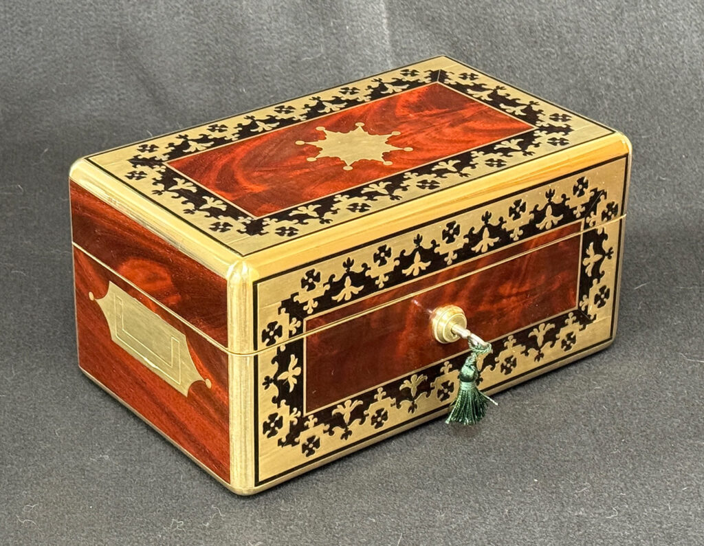 Front left view of an Antique Miniature Jewellery Box in Flame Mahogany with Brass & Ebony Inlay.