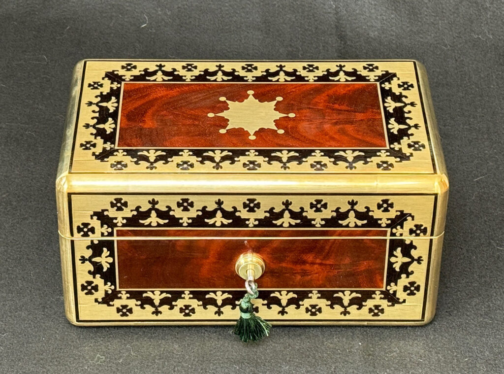Front view of an Antique Miniature Jewellery Box in Flame Mahogany with Brass & Ebony Inlay.
