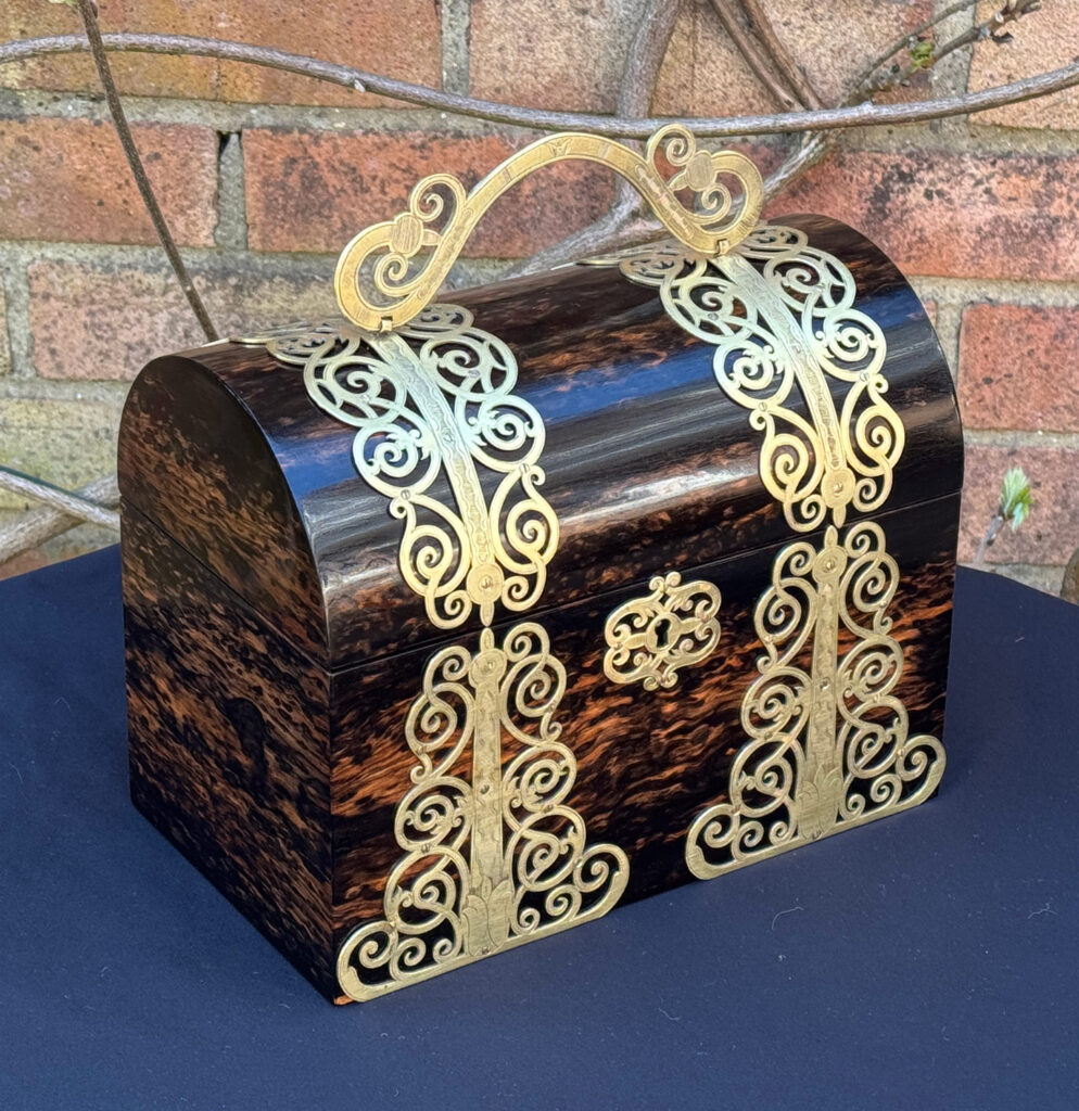 Front left view of an Antique Jewellery Box in Coromandel With Engraved Brass Overlay and handle raised.