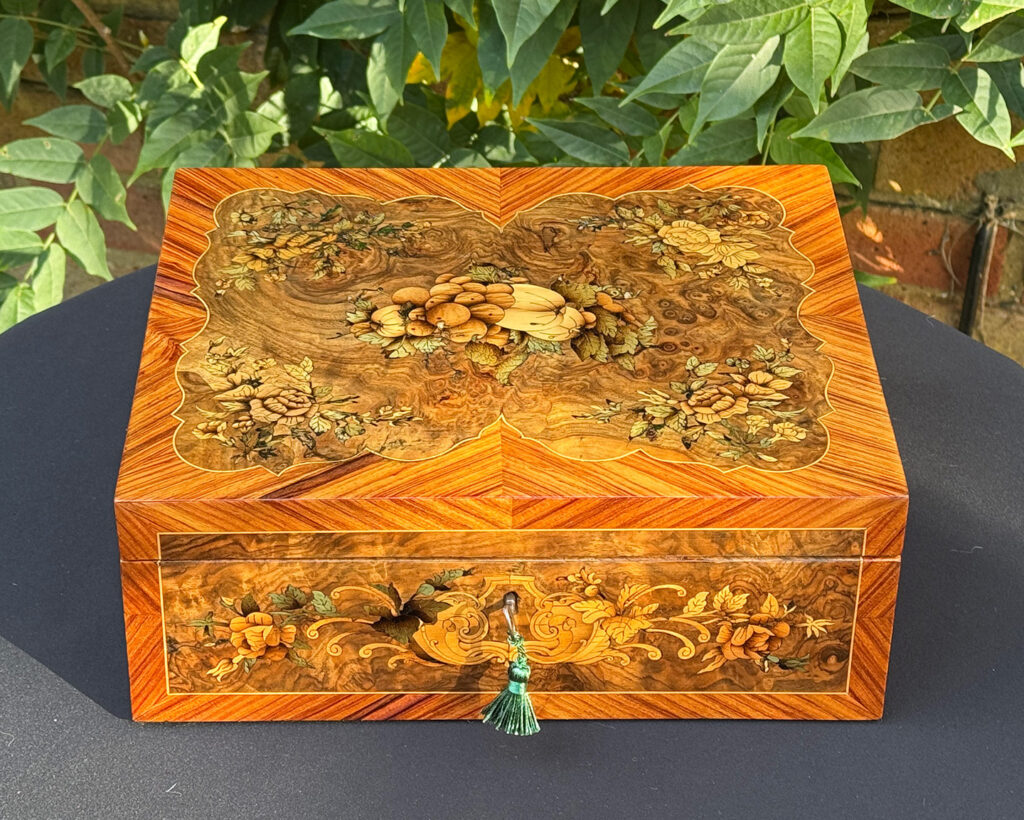 Front overhead view of an antique Georgian jewellery box in burr walnut & kingwood with floral marquetry inlay.