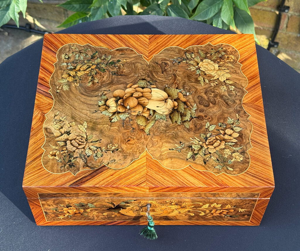 Top view of an antique Georgian jewellery box in burr walnut & kingwood with floral marquetry inlay.