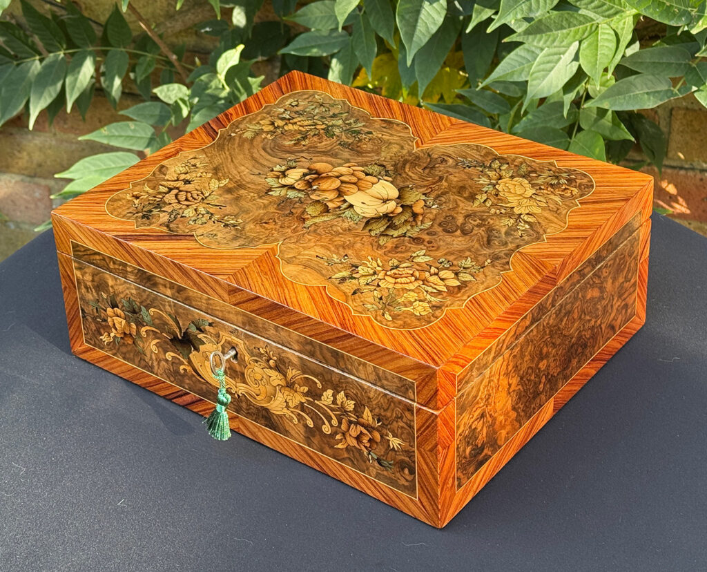Front right view of an antique Georgian jewellery box in burr walnut & kingwood with floral marquetry inlay.