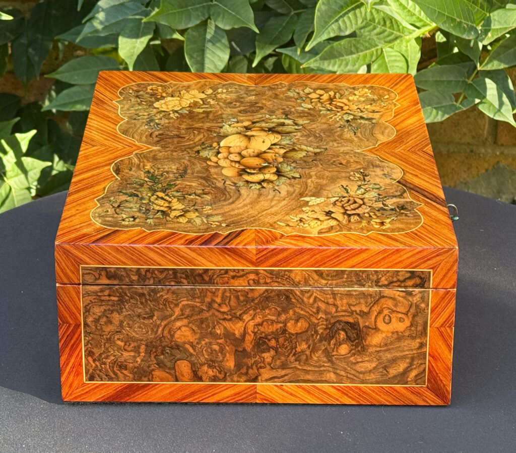 Left side view of an antique Georgian jewellery box in burr walnut & kingwood with floral marquetry inlay.