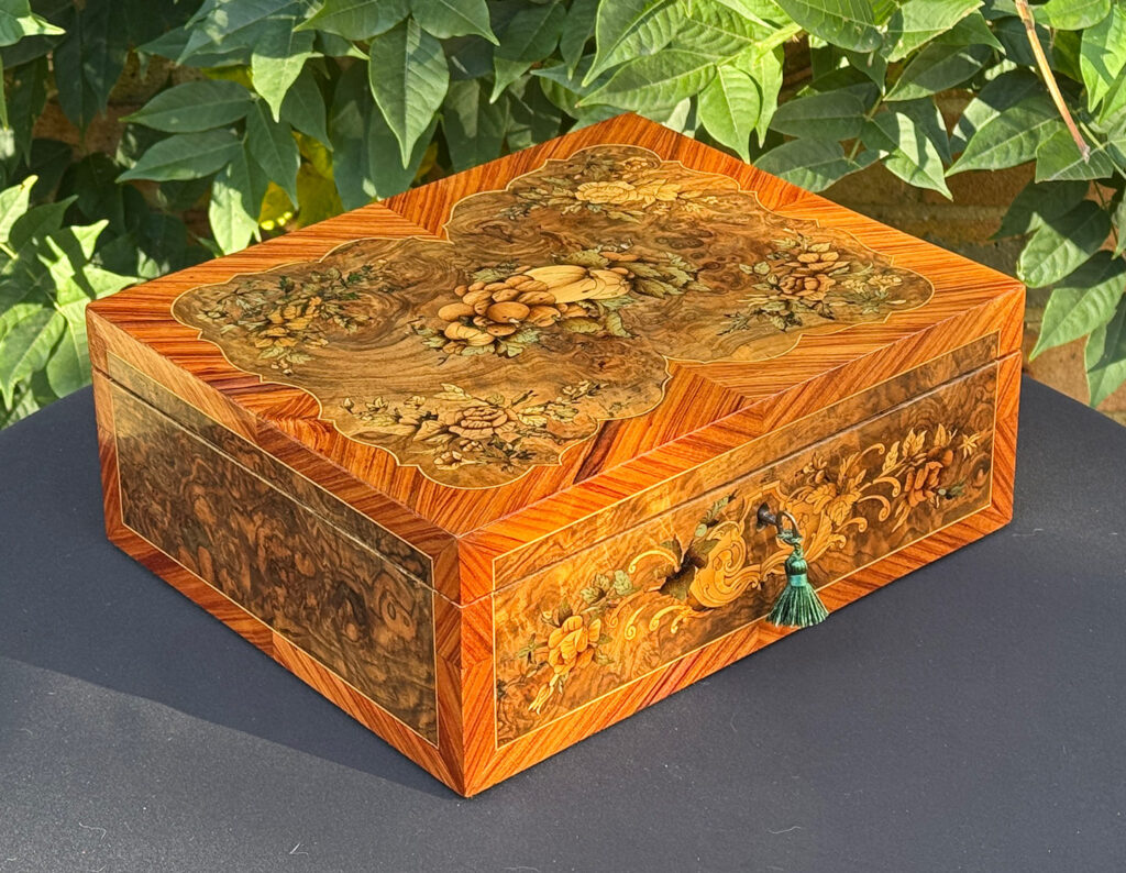 Front left view of an antique Georgian jewellery box in burr walnut & kingwood with floral marquetry inlay.