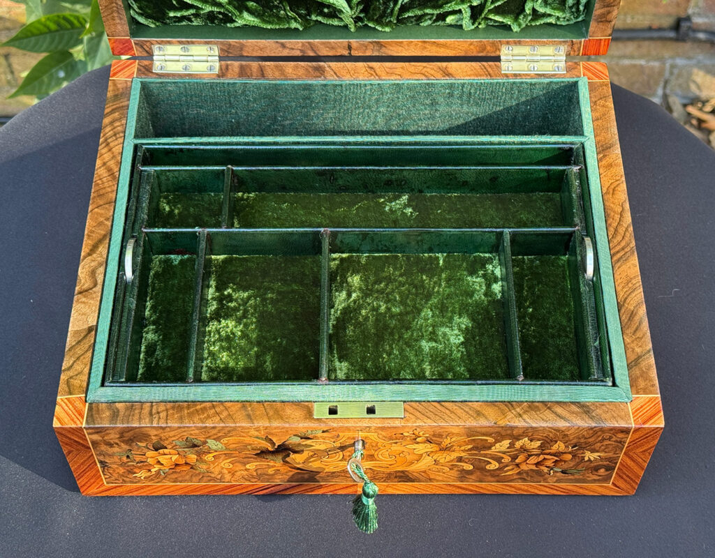 Close overhead internal view of an antique Georgian jewellery box in burr walnut & kingwood with floral marquetry inlay.