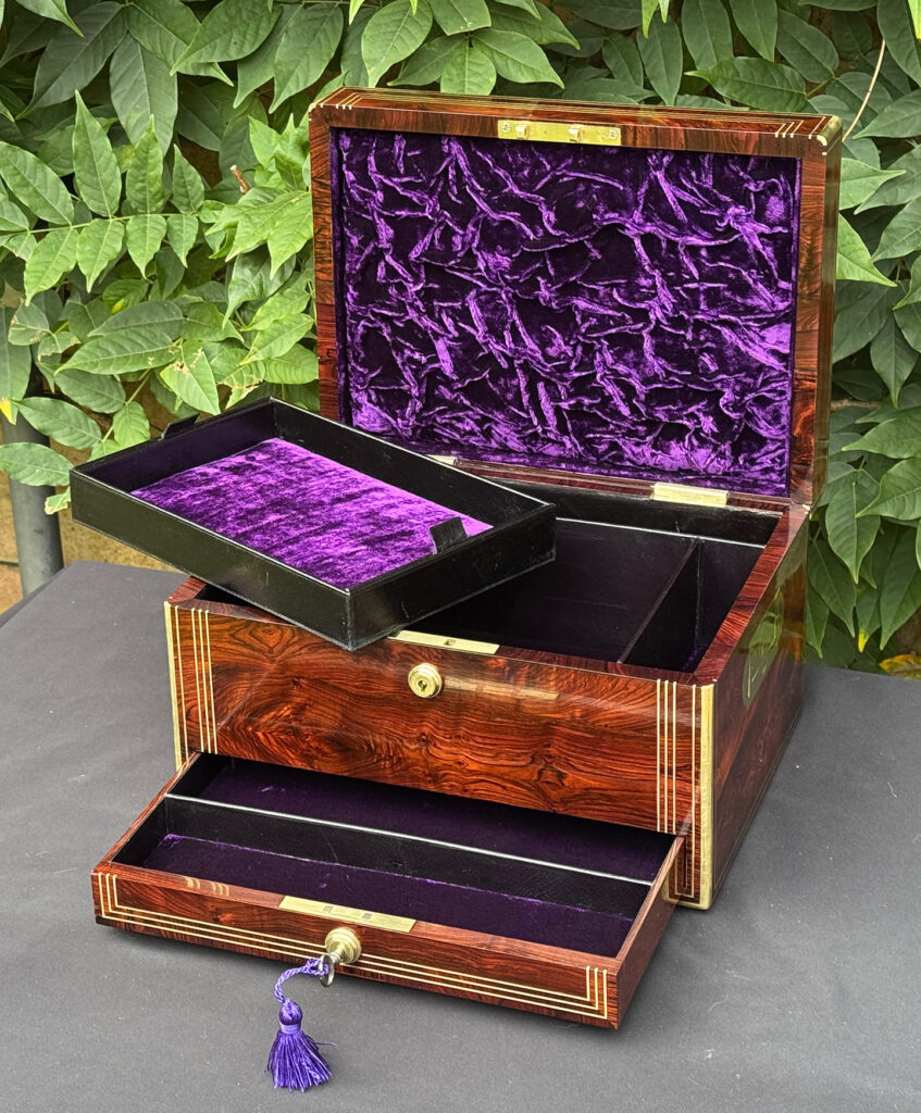 Front right internal view of an antique jewellery box in kingwood, by Halstaff & Hannaford, with tray removed and lower drawer opened.