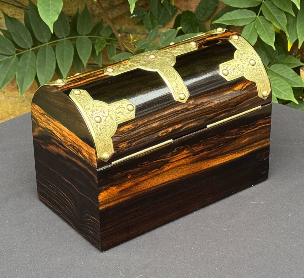 Rear right view of an antique jewellery box in coromandel with engraved brass overlay.
