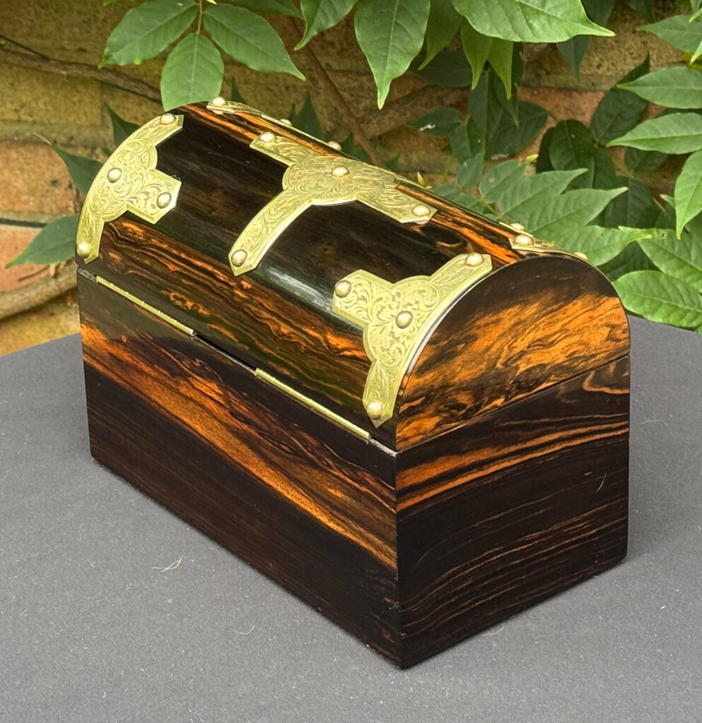 Rear left view of an antique jewellery box in coromandel with engraved brass overlay.