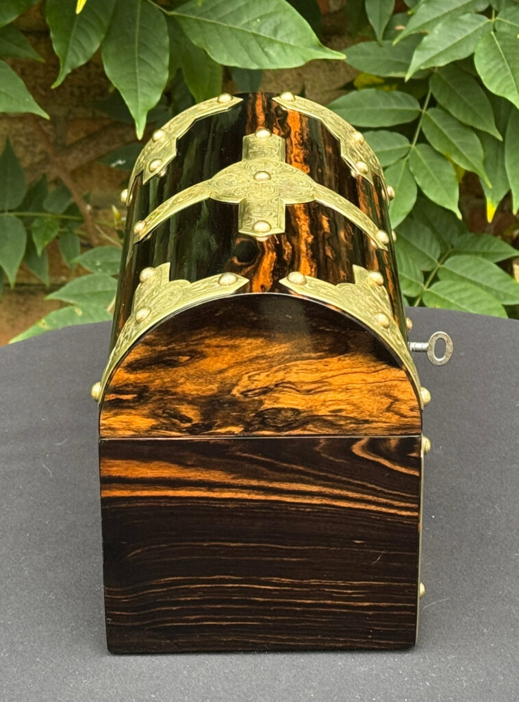 Left side view of an antique jewellery box in coromandel with engraved brass overlay.