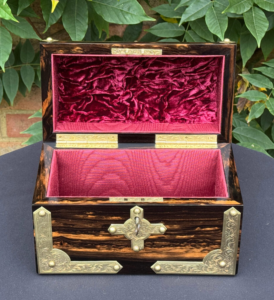 Front internal view of an antique jewellery box in coromandel with engraved brass overlay.