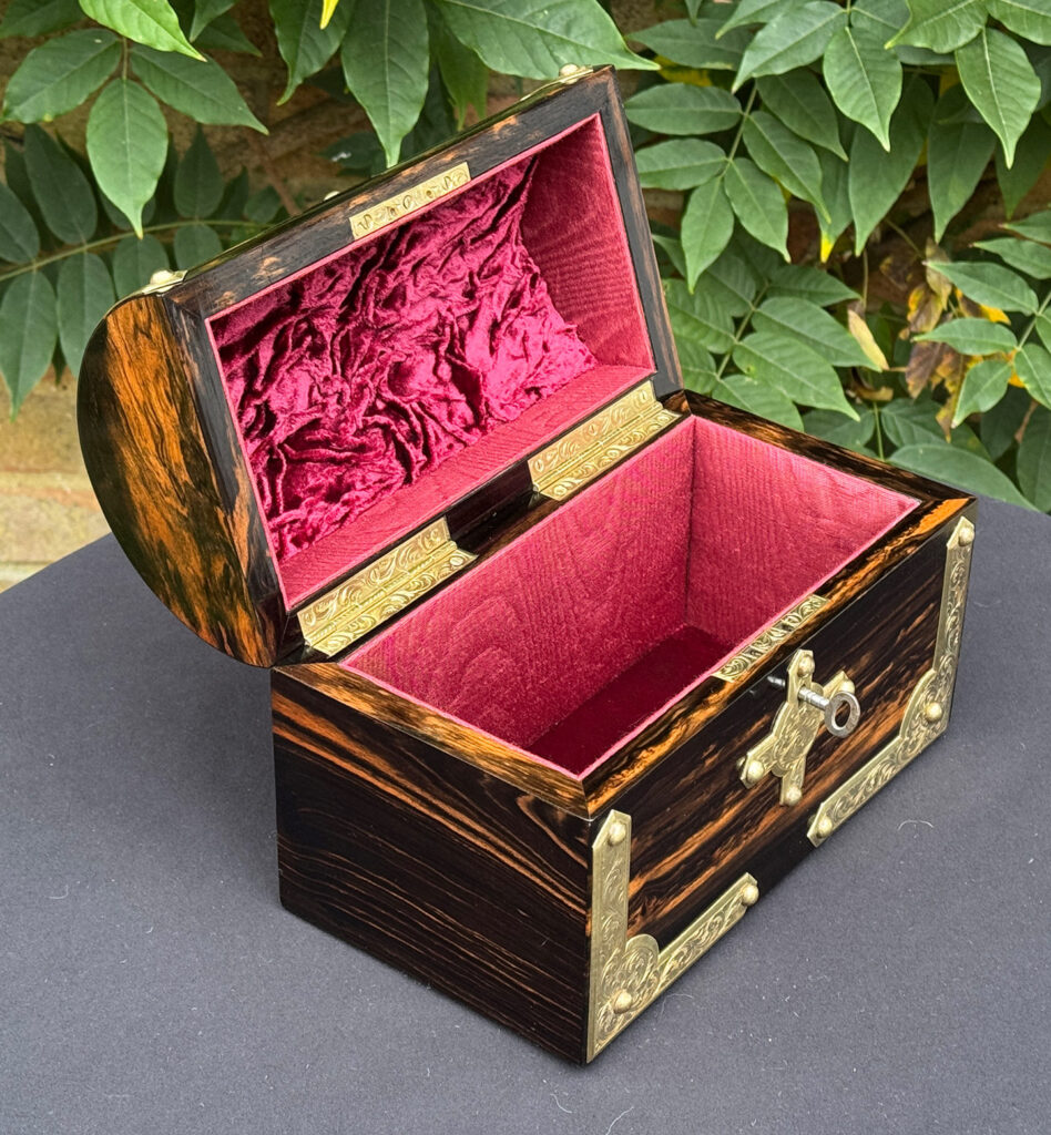 Front left internal view of an antique jewellery box in coromandel with engraved brass overlay.
