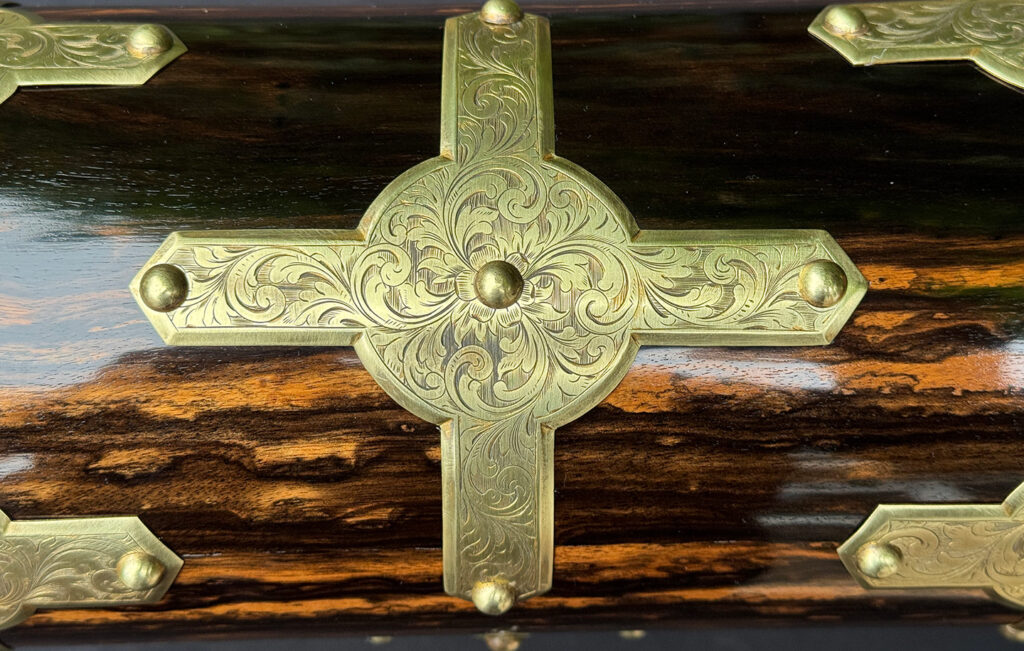 Close view of the engraved brass overlay from an antique jewellery box in coromandel.