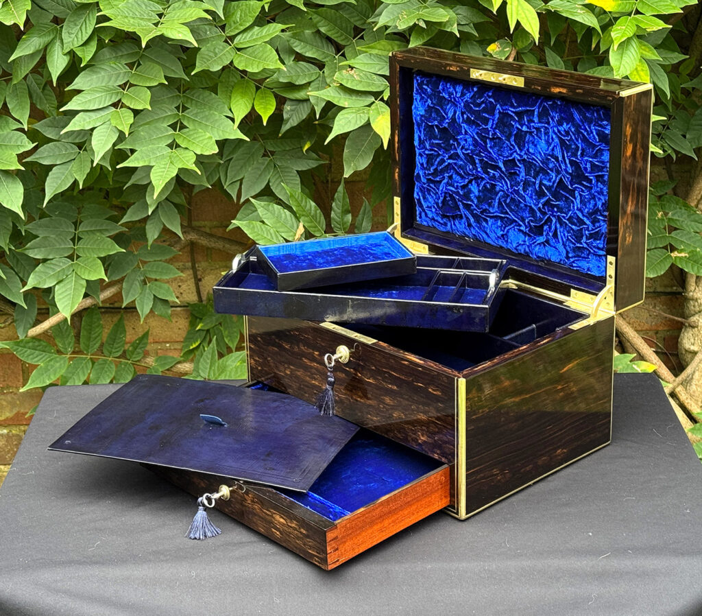 Front right internal view of an antique jewellery box in coromandel, by Charles Asprey, with trays and writing surface removed.