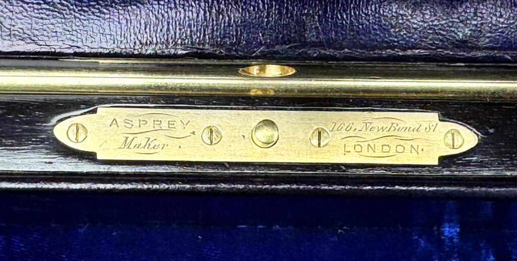 Close up view of the brass push button mount engraved with Asprey - Makers - 166 Bond St - London.