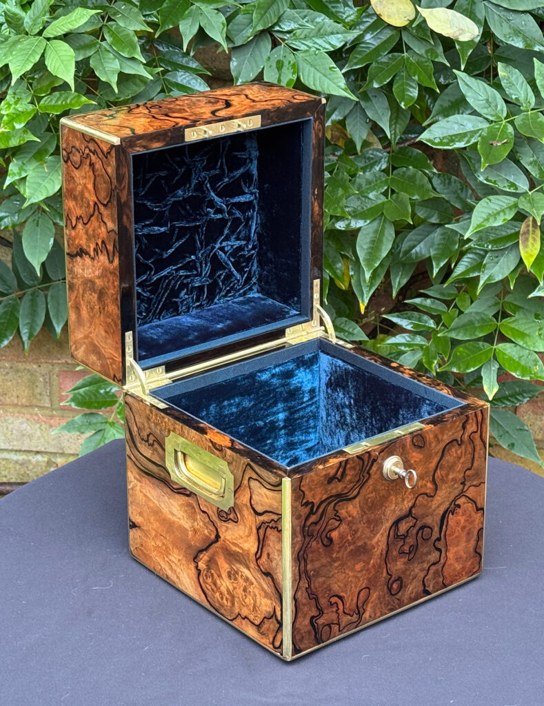 Front left interior view of an antique jewellery box in enhanced burr walnut.