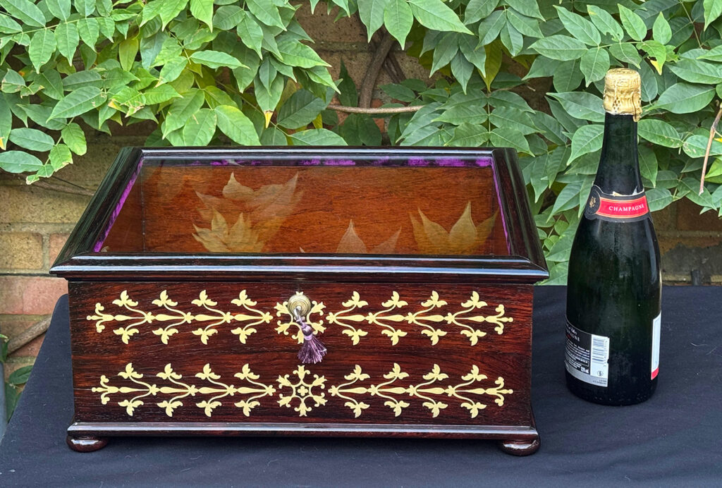 Size comparison view of an antique rosewood brass inlaid glass display jewellery box.