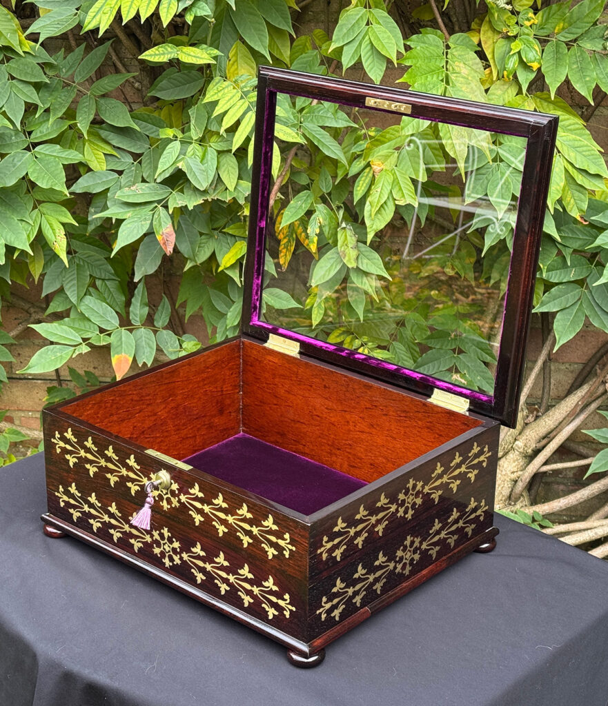 Front right internal view of an antique rosewood brass inlaid glass display jewellery box.