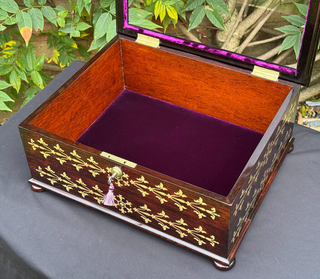 Overhead internal view of an antique rosewood brass inlaid glass display jewellery box.