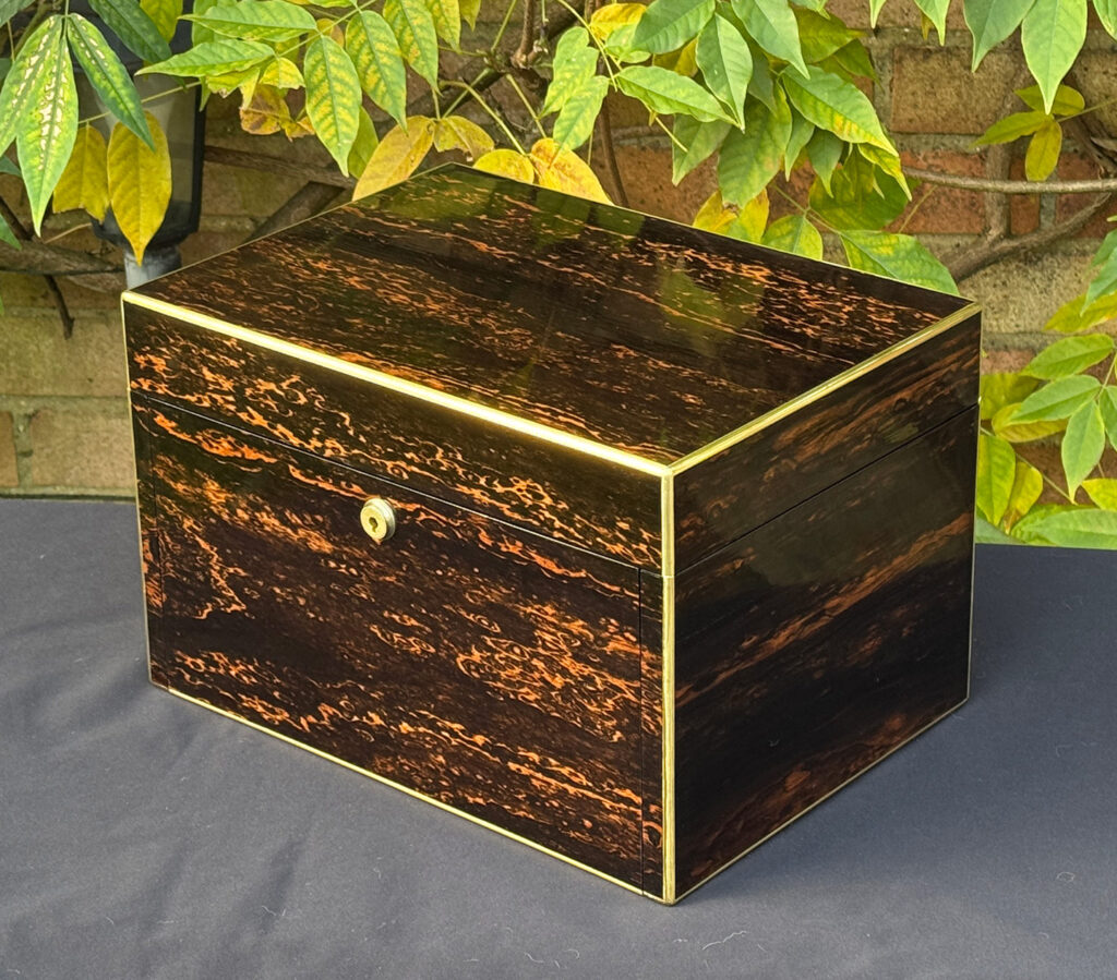Front right view of an antique jewellery box in coromandel with two concealed drawers.