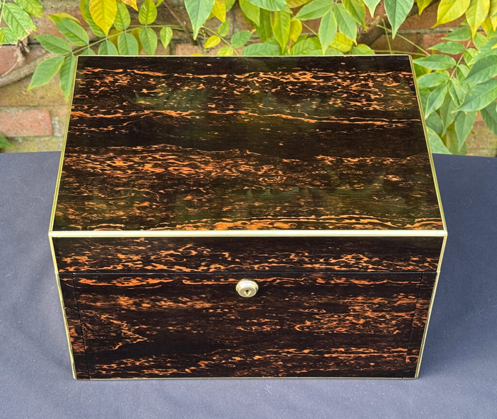Overhead view of an antique jewellery box in coromandel with two concealed drawers.