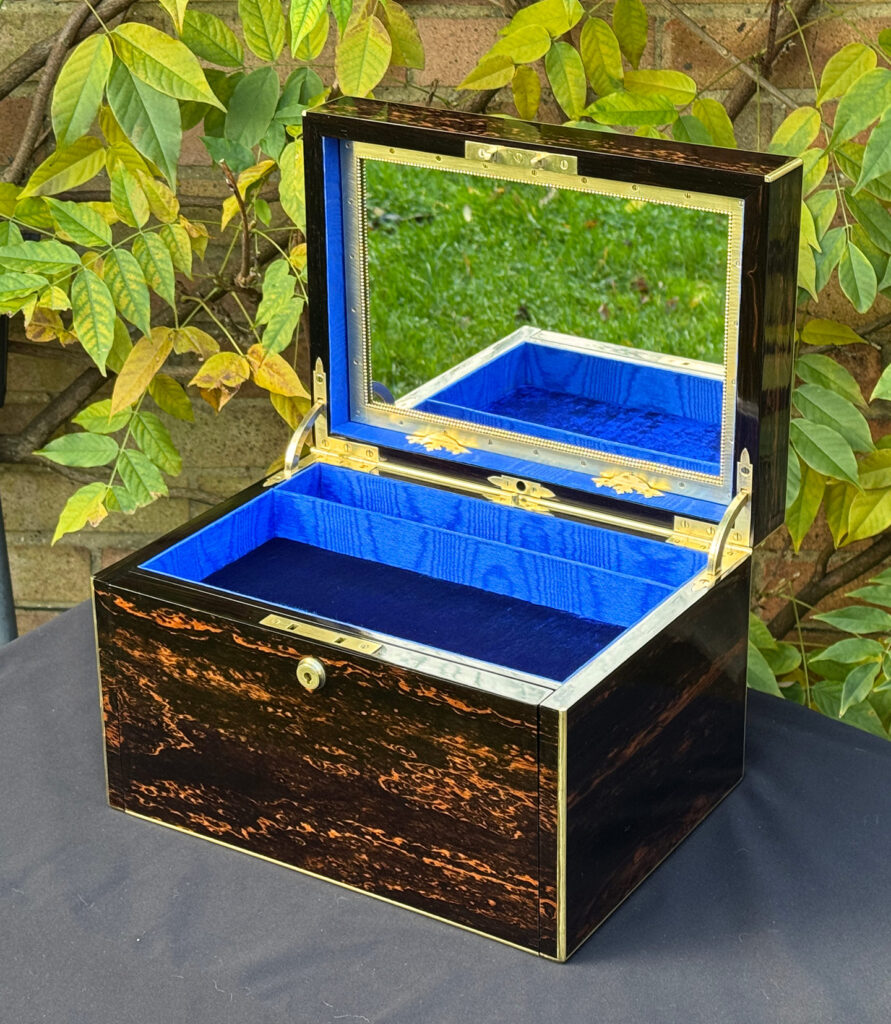Front right internal view of an antique jewellery box in coromandel with two concealed drawers.