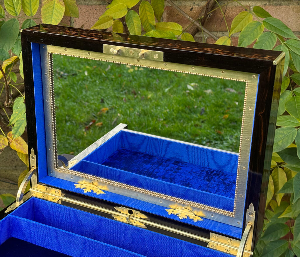 Close up of the decorative mirror frame from an antique jewellery box in coromandel with two concealed drawers.
