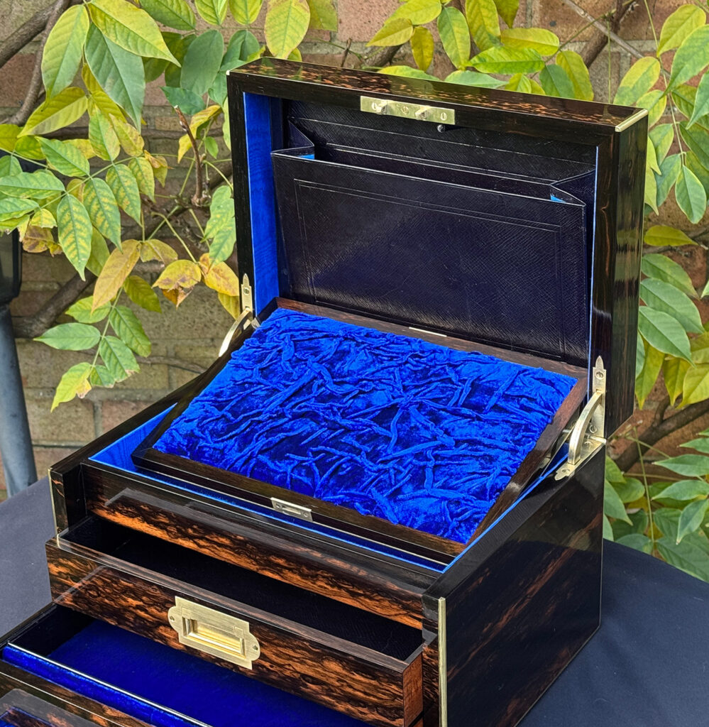 Front right internal view of an antique jewellery box in coromandel with two concealed drawers, with mirror frame dropped forward.