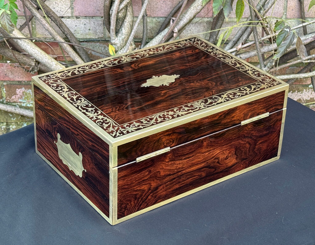 Rear right view of an antique jewellery box in Rosewood with scrollwork brass inlay, by Edwards.