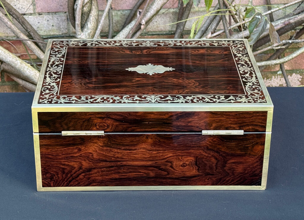 Rear view of an antique jewellery box in Rosewood with scrollwork brass inlay, by Edwards.