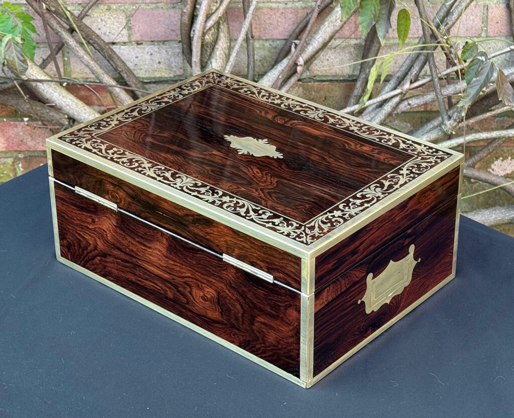 Rear left view of an antique jewellery box in Rosewood with scrollwork brass inlay, by Edwards.