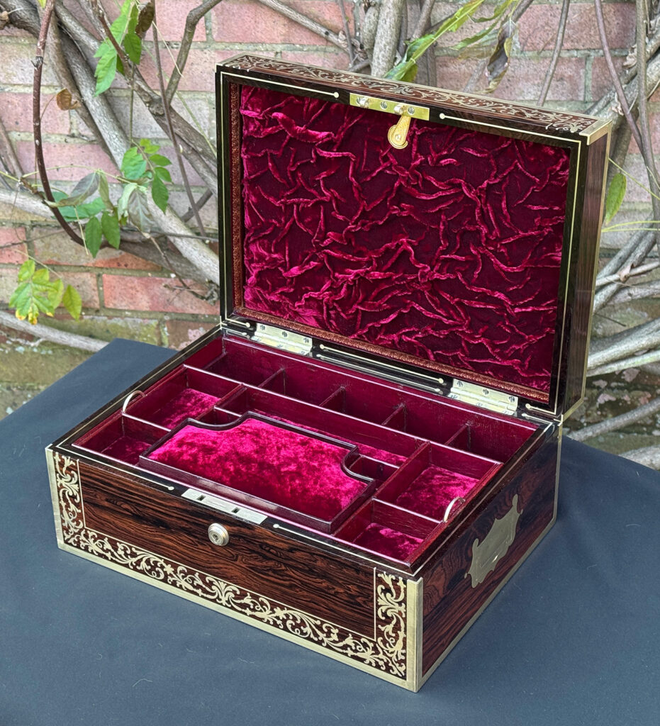 Front right internal view of an antique jewellery box in Rosewood with scrollwork brass inlay, by Edwards.