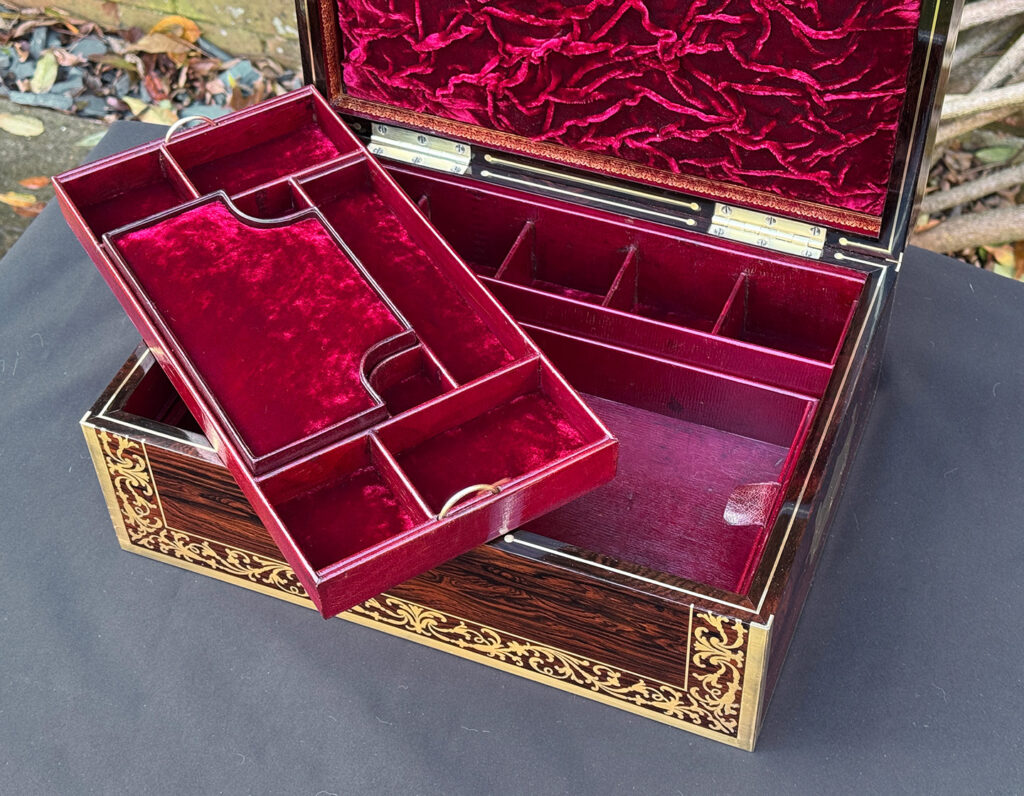 Internal view of an antique jewellery box in Rosewood with scrollwork brass inlay, by Edwards, with top tray removed,.