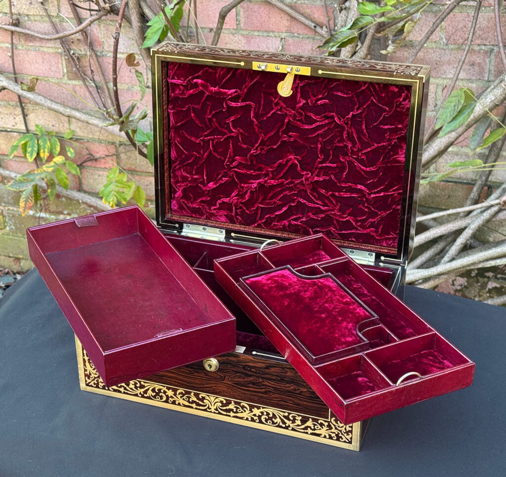 Internal view of an antique jewellery box in Rosewood with scrollwork brass inlay, by Edwards, with both trays removed,.