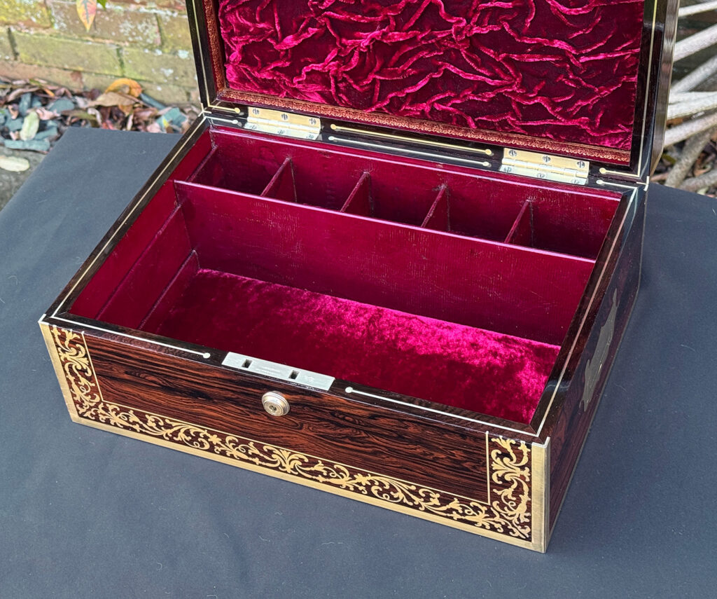 Internal view of the base section of an antique jewellery box in Rosewood with scrollwork brass inlay, by Edwards.