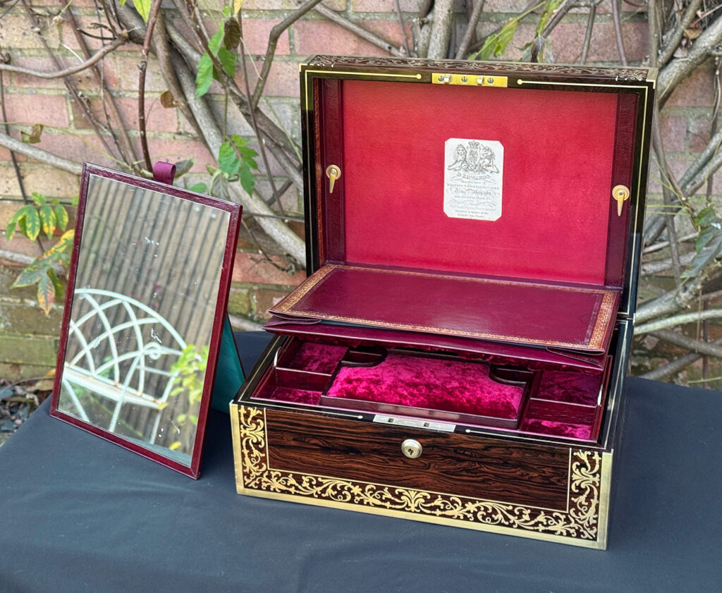 Front right internal view of an antique jewellery box in Rosewood with scrollwork brass inlay, by Edwards, with the freestanding mirror displayed.