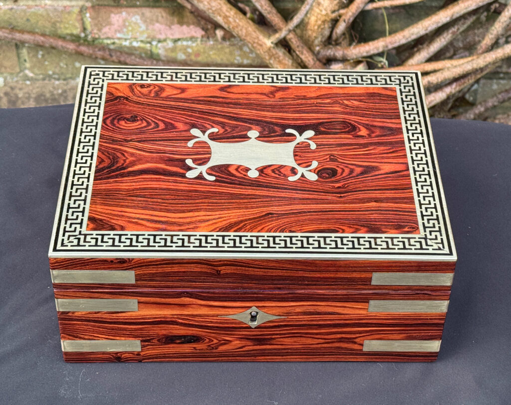 Overhead view of an antique jewellery box in kingwood with brass inlay.