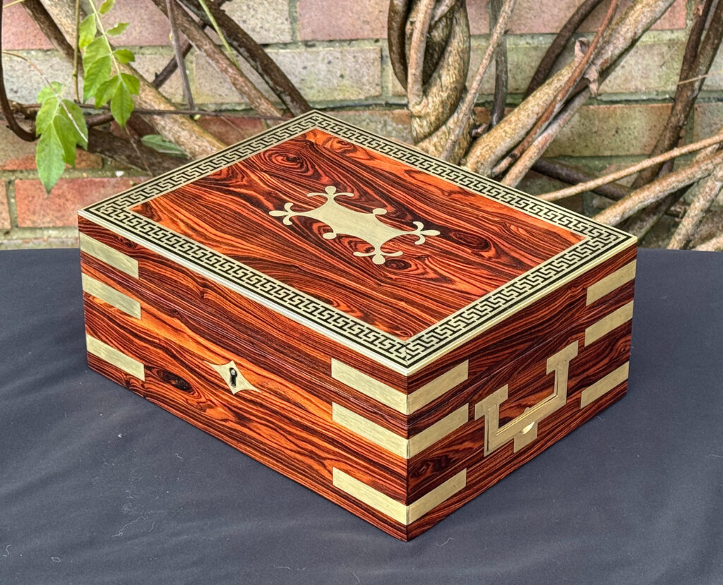 Front right view of an antique jewellery box in kingwood with brass inlay.