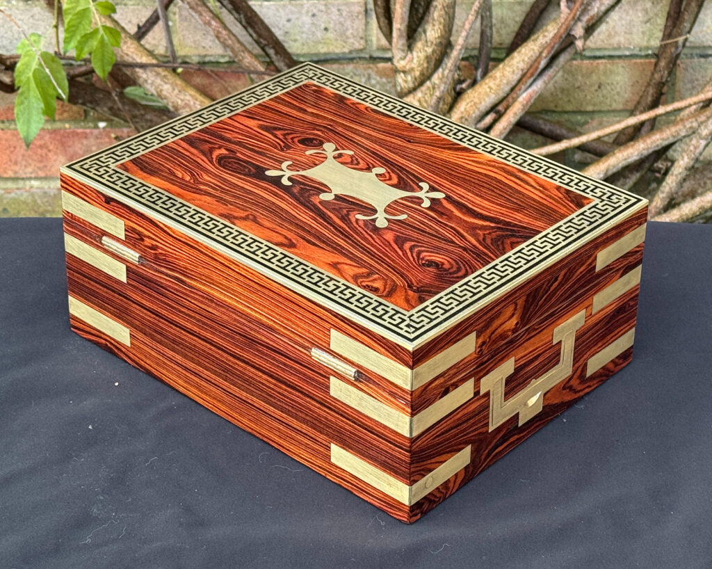 Rear left view of an antique jewellery box in kingwood with brass inlay.