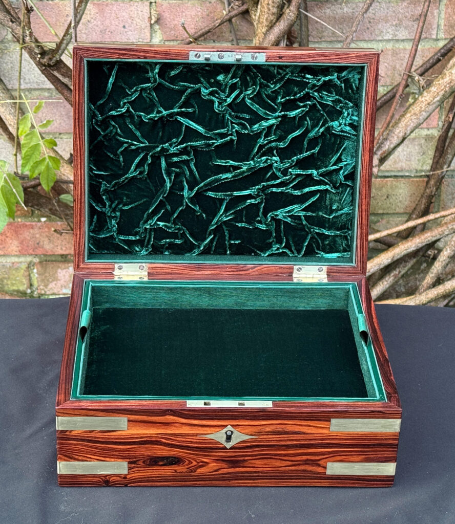 Front interior view of an antique jewellery box in kingwood with brass inlay.
