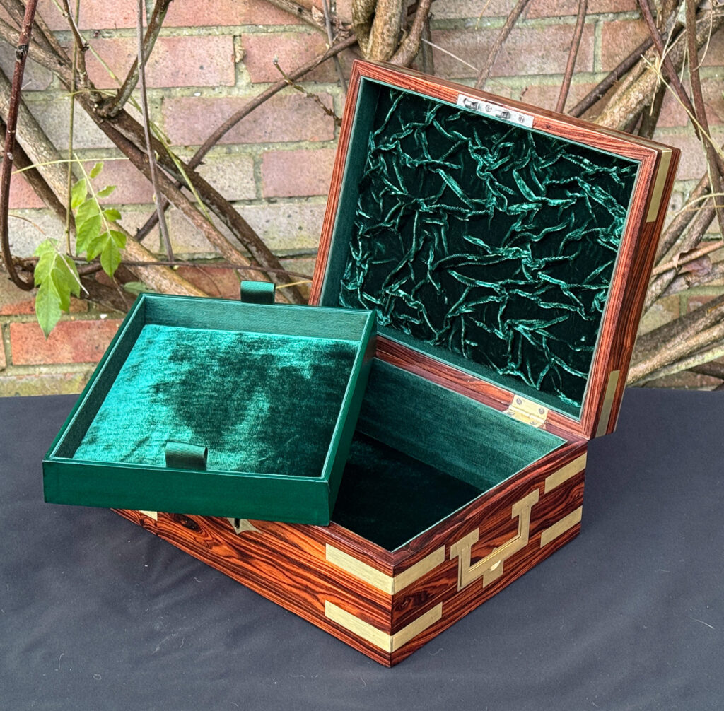 Front right interior view of an antique jewellery box in kingwood with brass inlay, with tray removed.