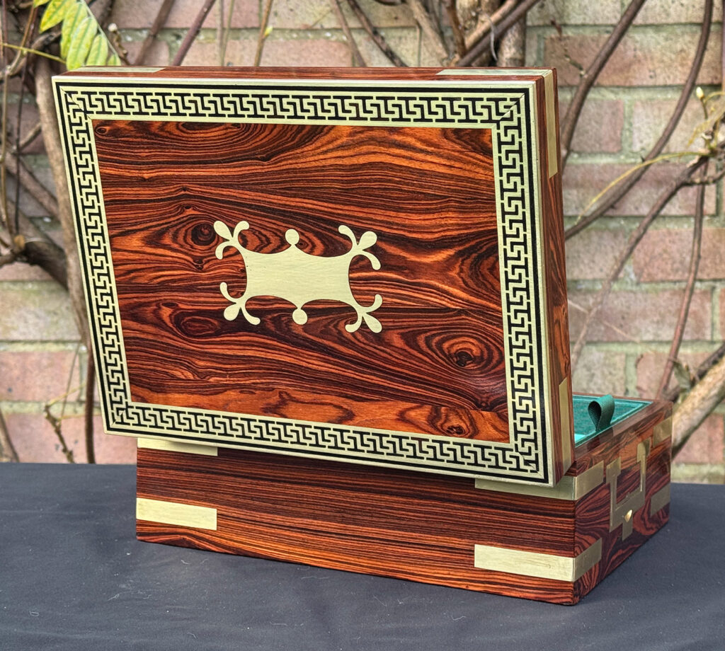 Rear opened view of an antique jewellery box in kingwood with brass inlay.