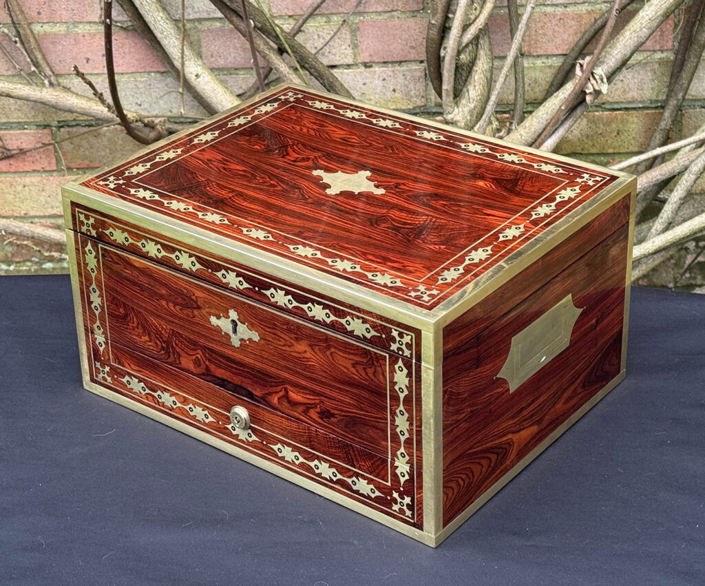 Front right view of an antique jewellery box in kingwood with decorative brass inlay.